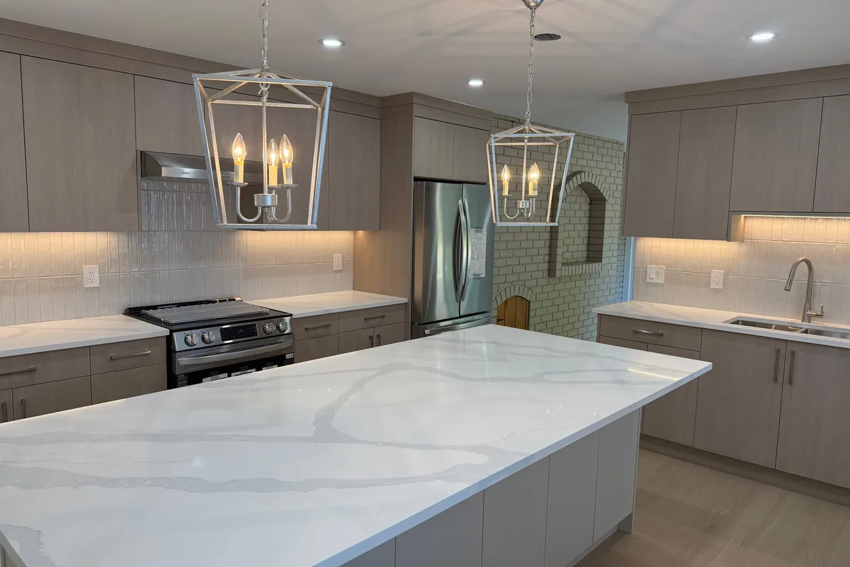 Kitchen range wall with taupe cabinetry, a tiled backsplash, and a brick-lined arch niche
